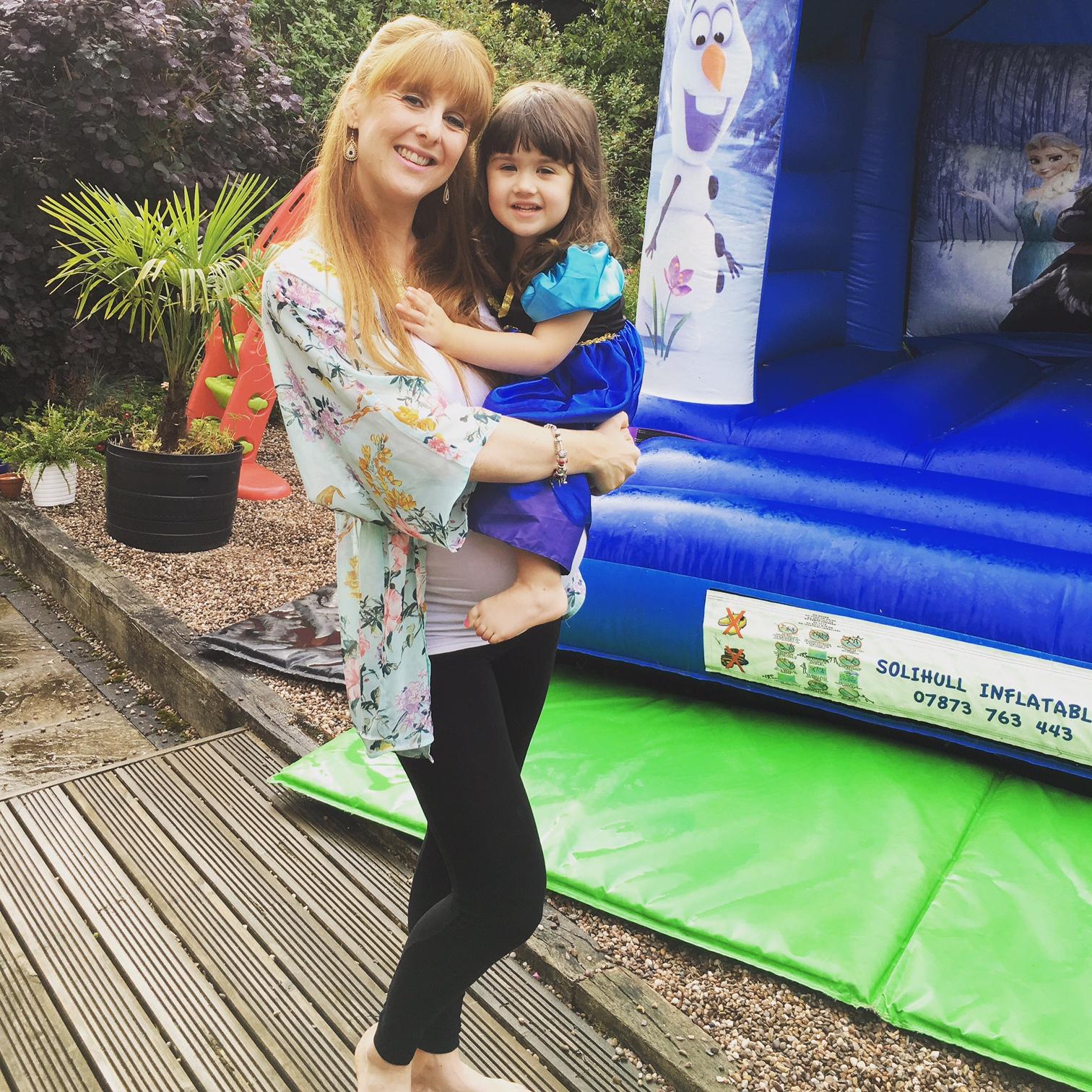 mum and daughter in front of a bouncy castle