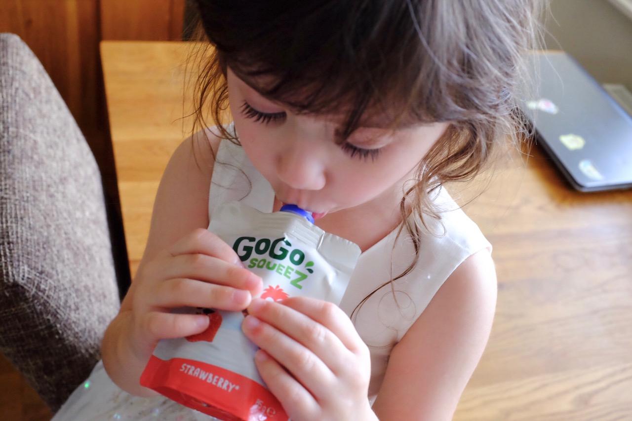 girl drinking a gogo squeez yoghurt