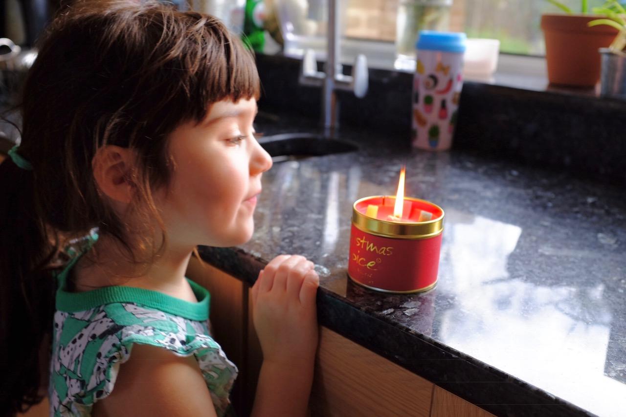 girl looking at a christmas candle
