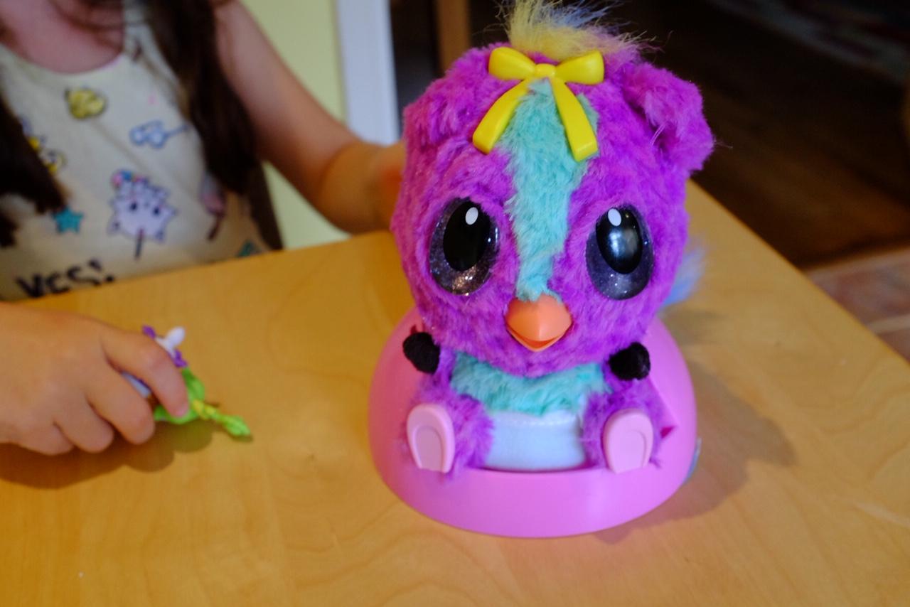 Girl Hatchimals HatchiBabies is sitting in the high chair