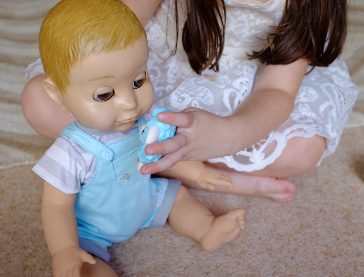 Girl playing with Lamby and Luvabeau doll