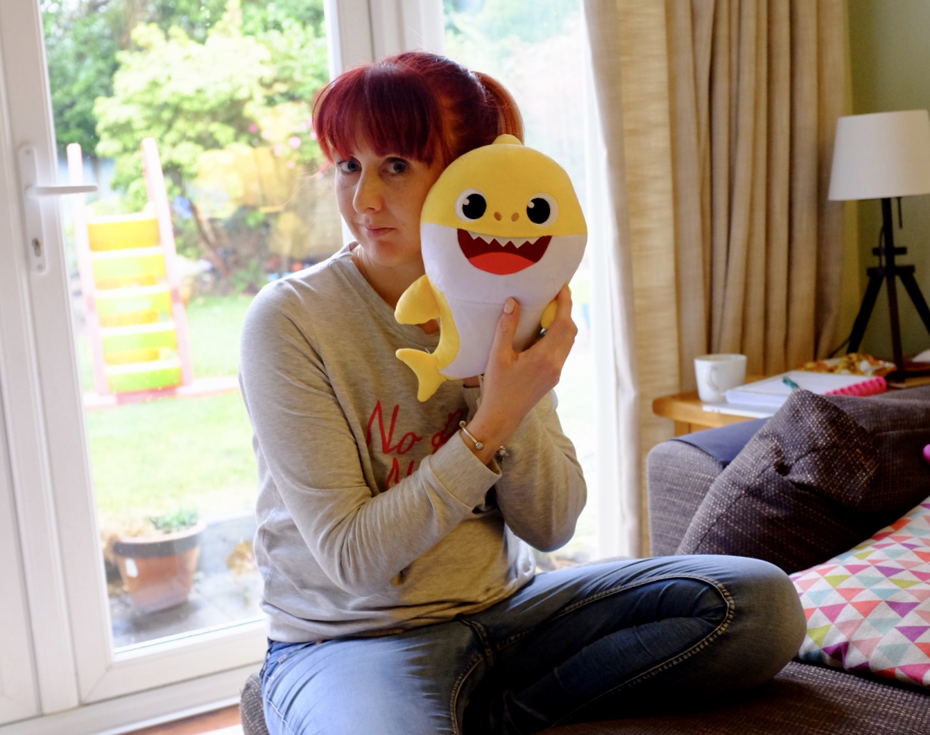 red head holding a baby shark plush