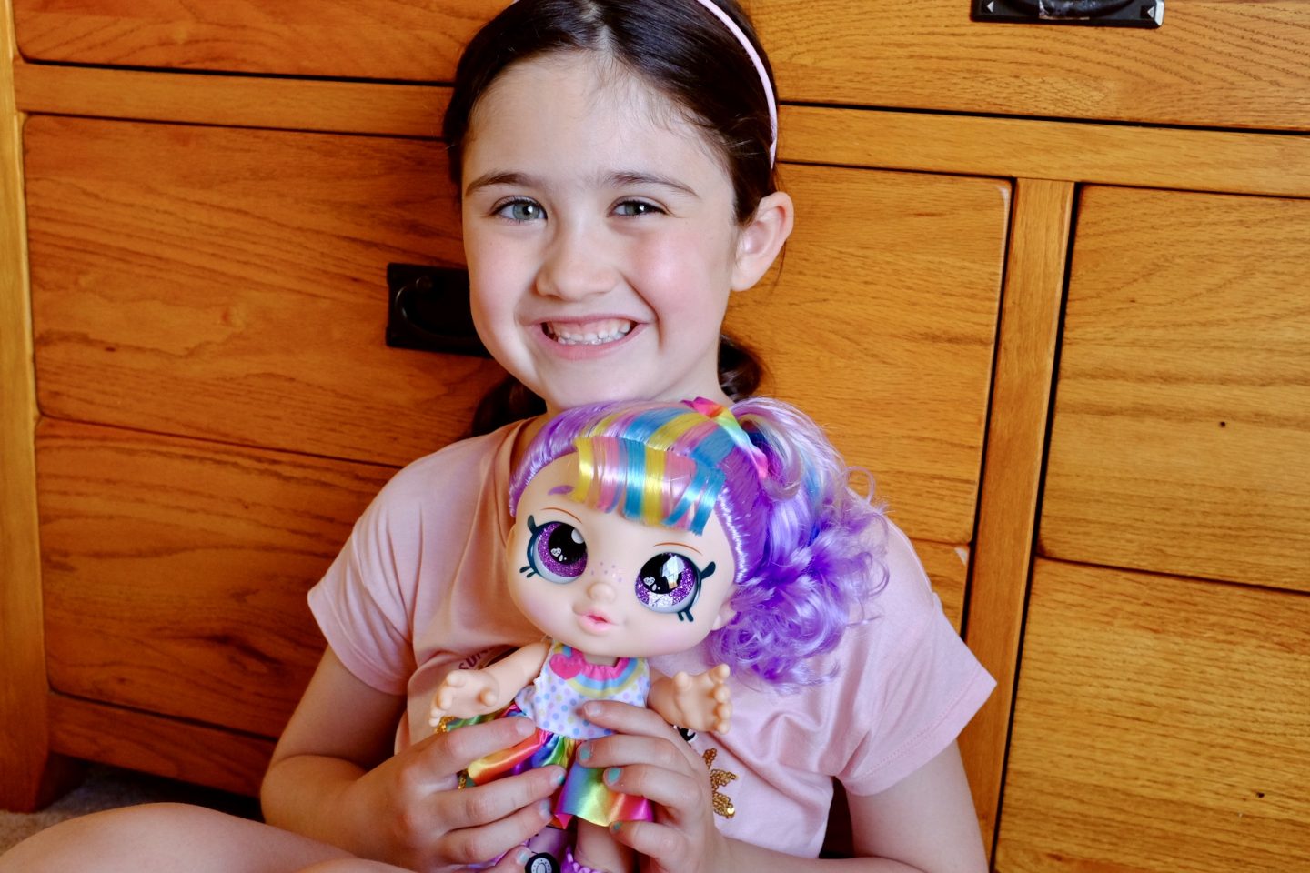 girl holding kindi kids rainbow kate doll