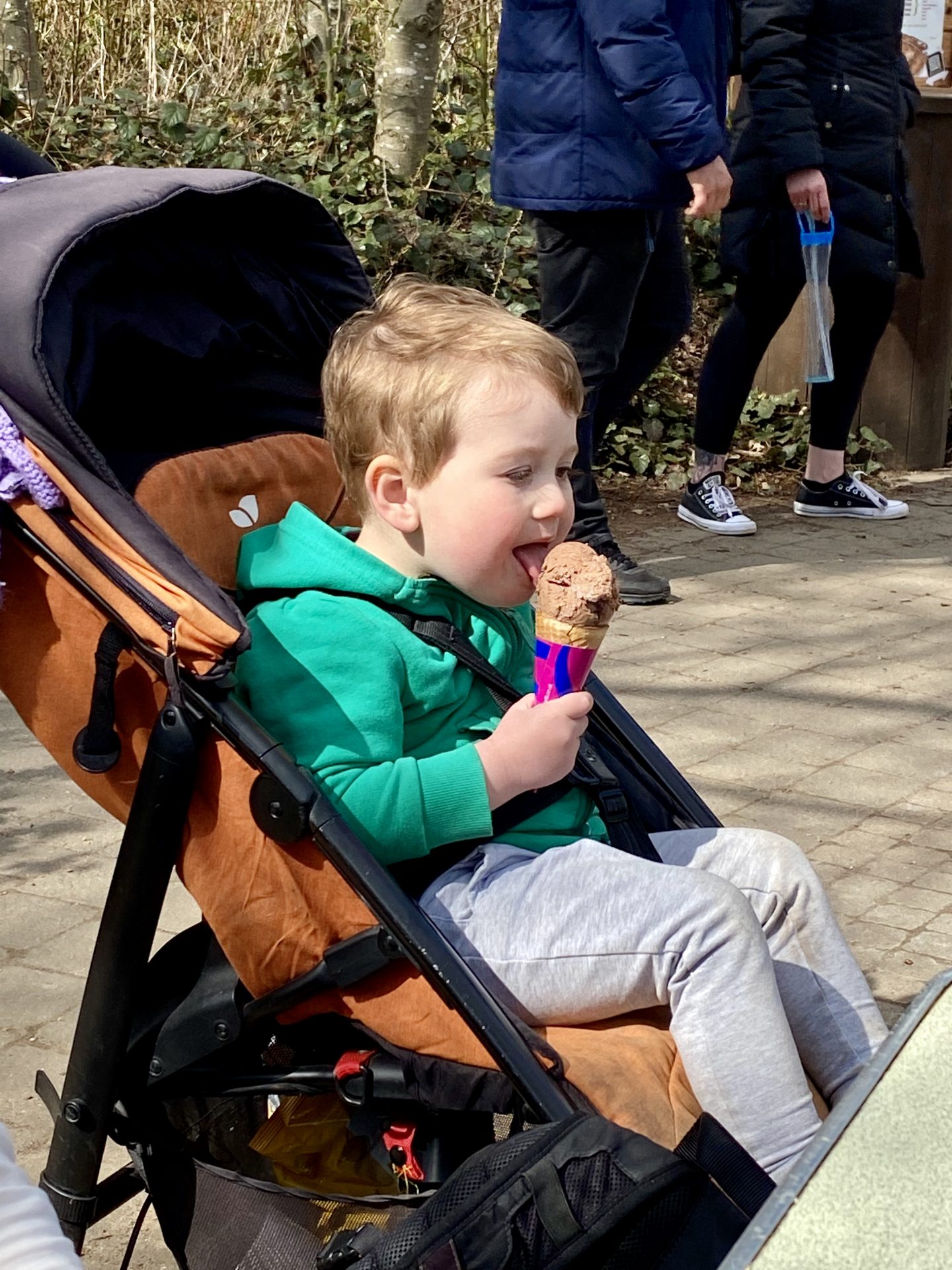 toddler eating an ice-cream in a buggy