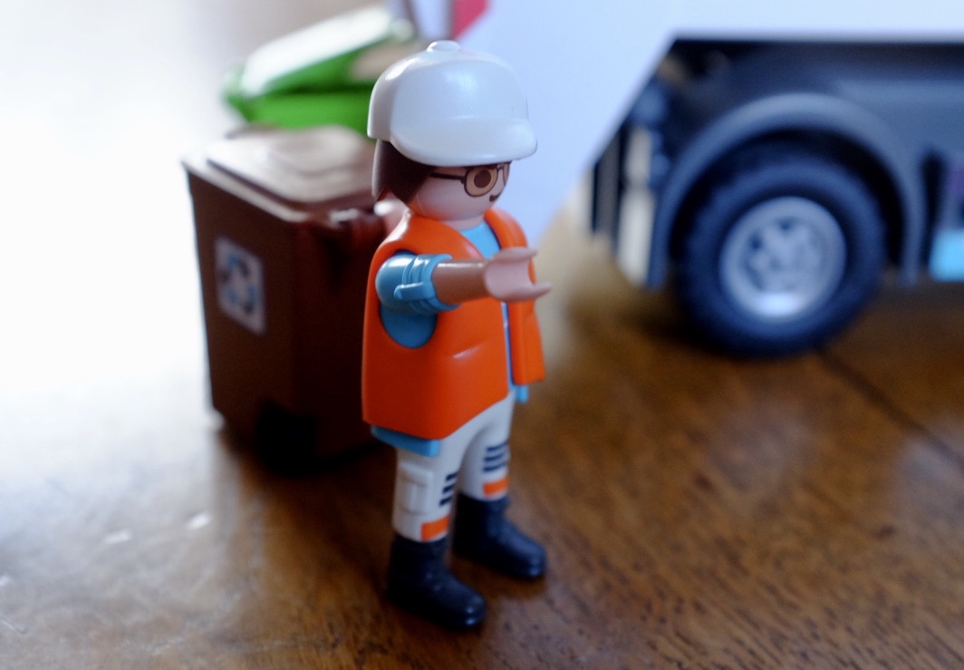 playmobil figure pulling a recycling bin