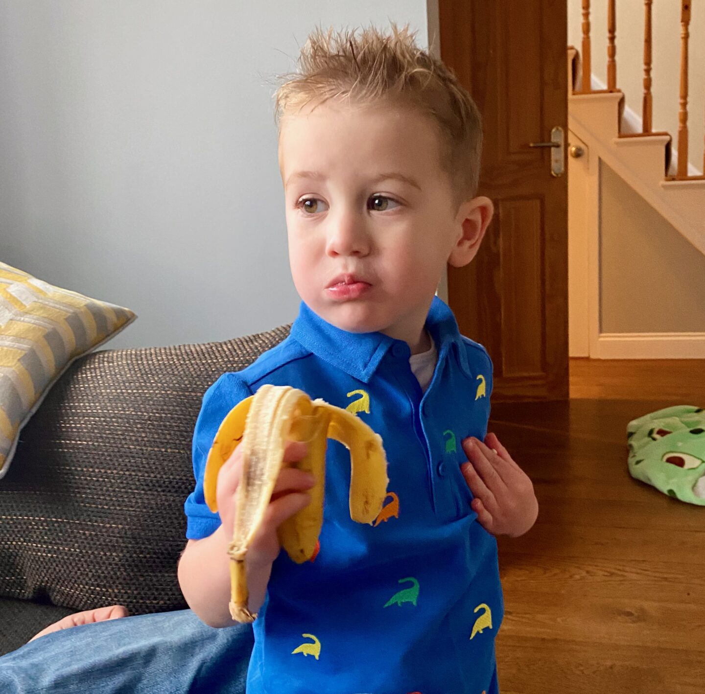 little blonde boy eating a banana